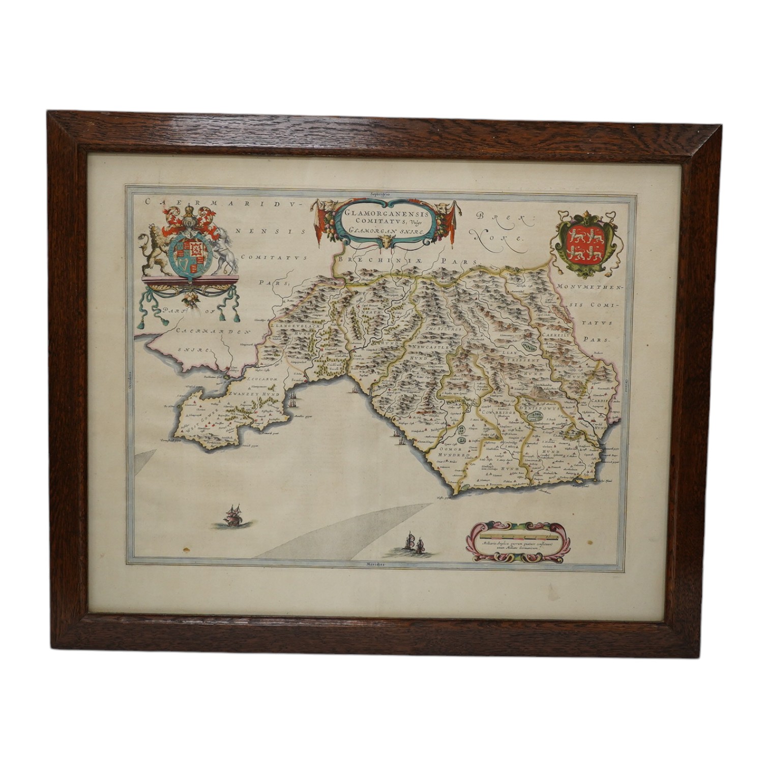 An oak cased collection of rifle and shooting medals disguised as a framed map of Glamorganshire, containing hallmarked silver medals engraved to the awardees, cloth badges for Glamorgan Rifle Association, bronze rifle a